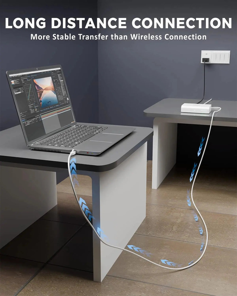 Laptop on a desk with a cable running along the floor, emphasizing long-distance connection.