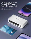 Small white device with multiple ports on a dark background, next to a smartphone and credit card for scale.