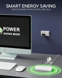 Computer setup with power saving mode display and smart energy saving device on desk.