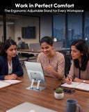 Three women working at a desk with an ergonomic adjustable stand for a tablet, in an office setting.